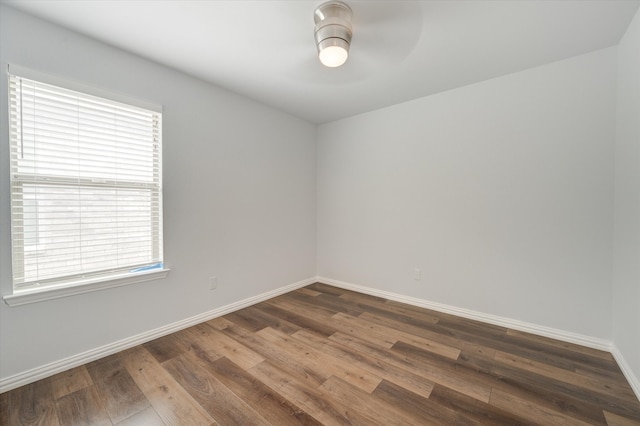 empty room with ceiling fan and dark hardwood / wood-style flooring