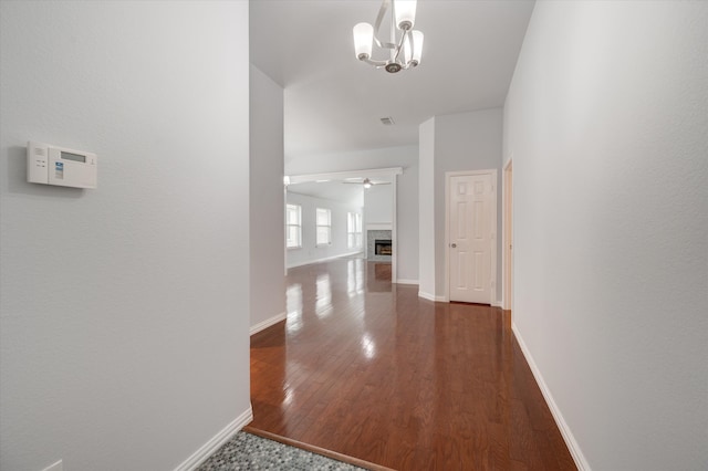 corridor featuring dark hardwood / wood-style floors and a chandelier