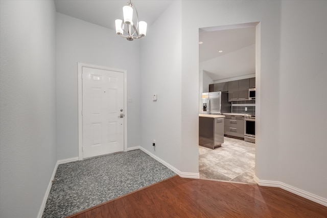 foyer entrance with a chandelier and light wood-type flooring