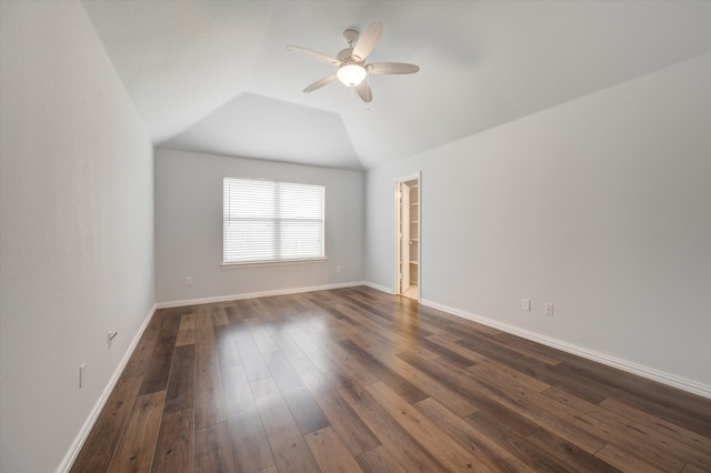 empty room with ceiling fan, vaulted ceiling, and dark hardwood / wood-style flooring