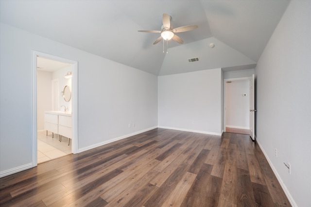 empty room featuring dark hardwood / wood-style floors, ceiling fan, and vaulted ceiling