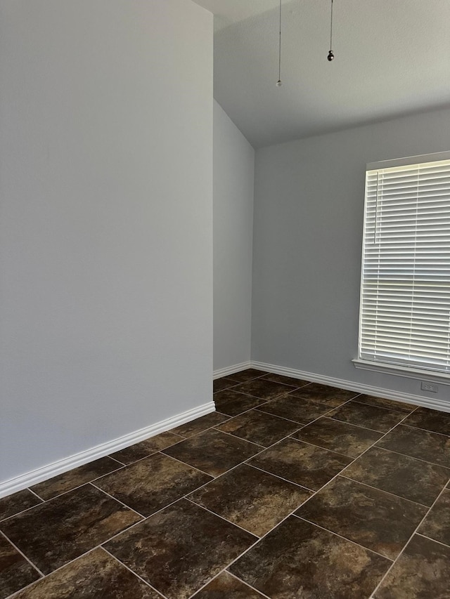 unfurnished room featuring lofted ceiling