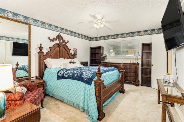 bedroom featuring ceiling fan, a textured ceiling, and light colored carpet