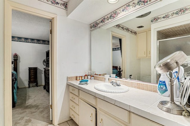 bathroom featuring vanity, an enclosed shower, a textured ceiling, and toilet