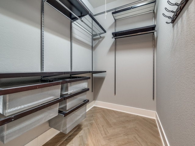 walk in closet with light parquet flooring