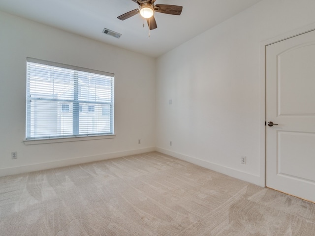 empty room featuring ceiling fan and light colored carpet