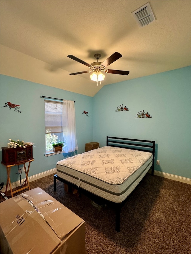 carpeted bedroom with ceiling fan, a textured ceiling, and vaulted ceiling