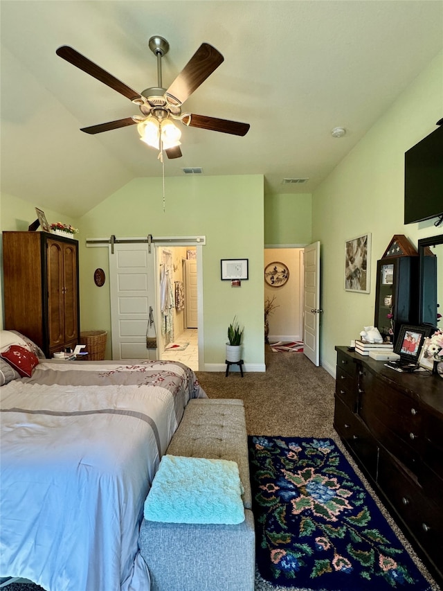 carpeted bedroom with ceiling fan, lofted ceiling, and a barn door