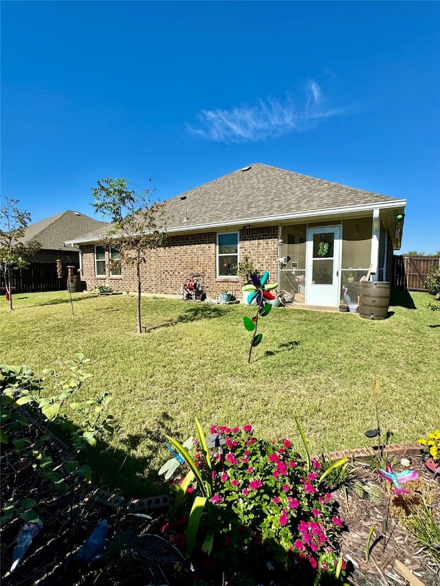 rear view of property featuring a lawn