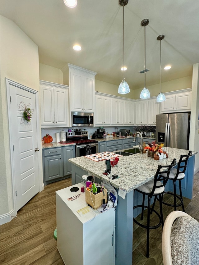 kitchen featuring white cabinetry, appliances with stainless steel finishes, and a kitchen island with sink