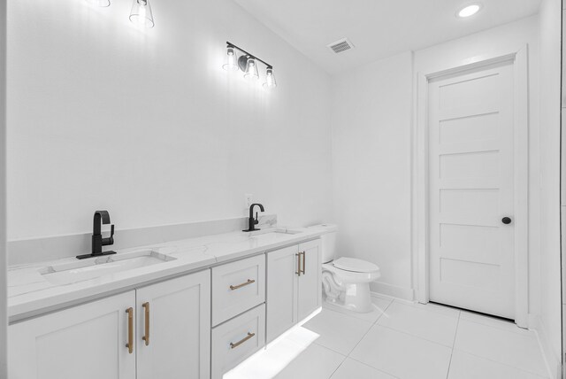 bathroom with tile patterned flooring, vanity, and toilet