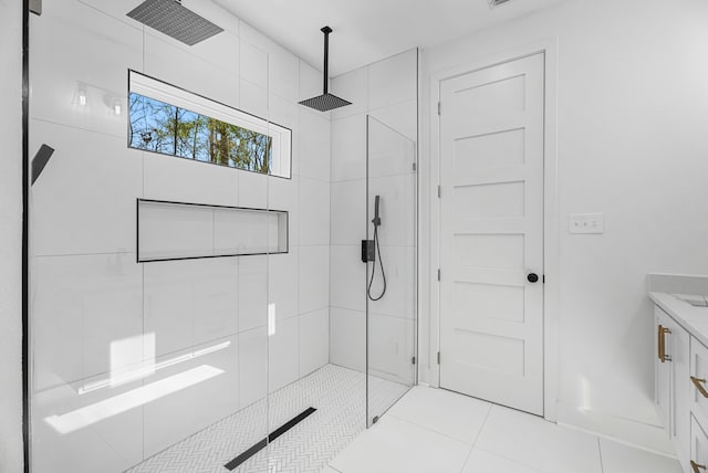 bathroom featuring tile patterned floors, vanity, and a tile shower