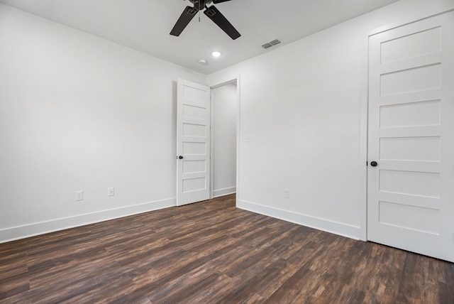 spare room with dark hardwood / wood-style flooring and ceiling fan