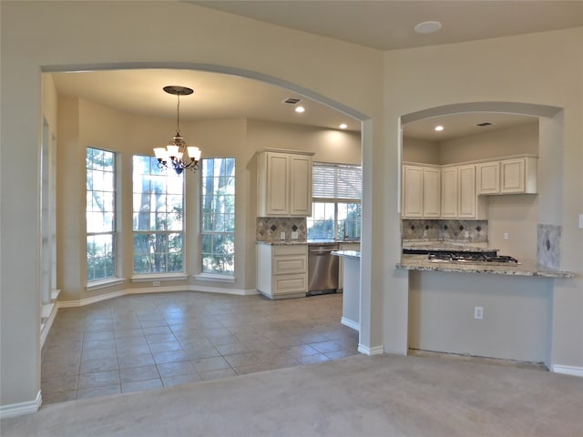 kitchen with dishwasher, cream cabinetry, pendant lighting, light colored carpet, and light stone counters