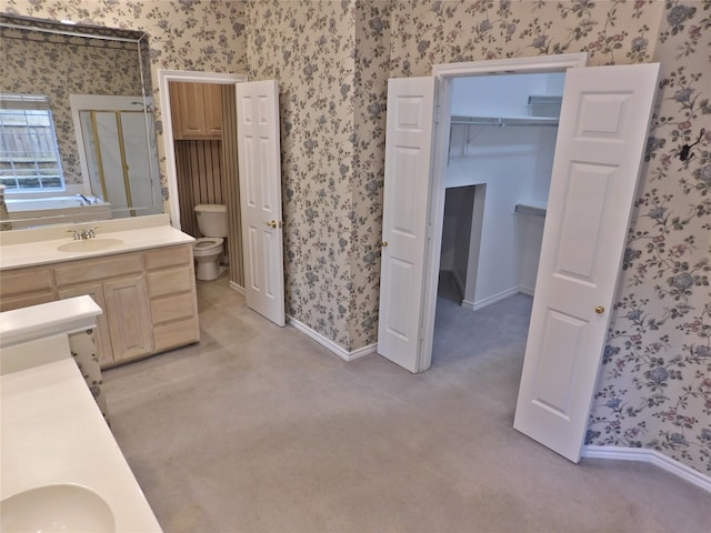 bathroom featuring vanity, toilet, and walk in shower