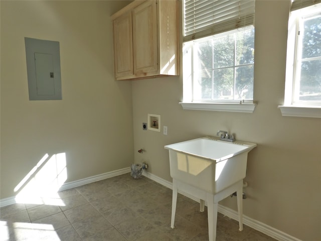 laundry room featuring electric panel, hookup for a washing machine, light tile patterned floors, and cabinets