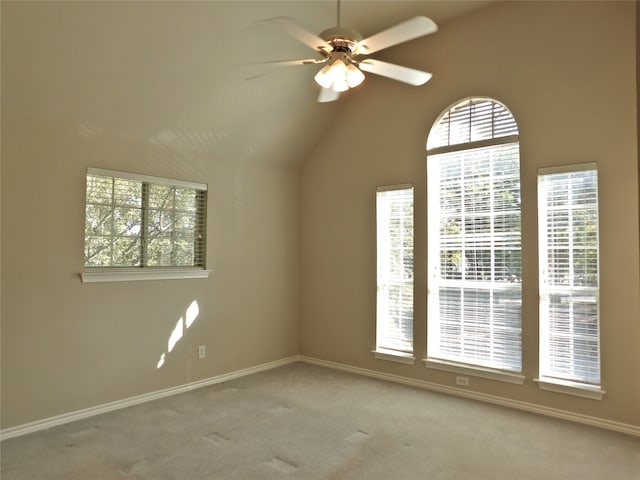 spare room with ceiling fan, a healthy amount of sunlight, lofted ceiling, and light carpet