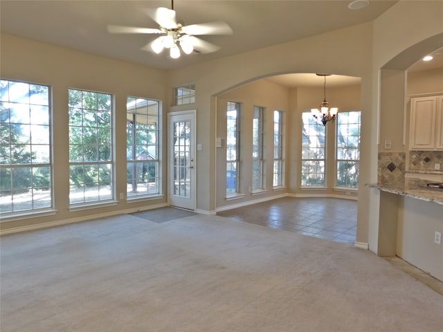 interior space with a healthy amount of sunlight and ceiling fan with notable chandelier