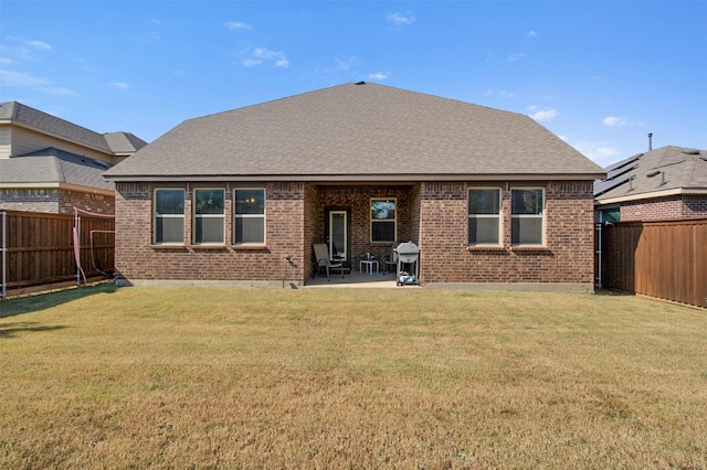 back of property with a yard and a patio area