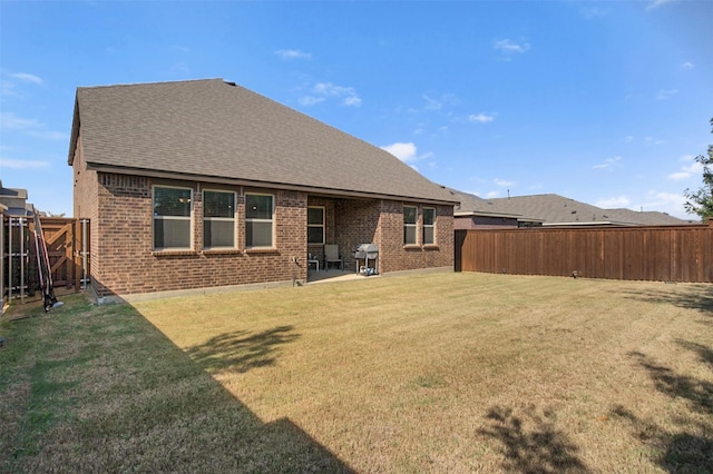 rear view of property with a lawn and a patio