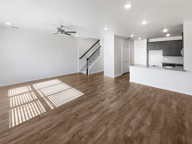 unfurnished living room with dark hardwood / wood-style floors, sink, and ceiling fan