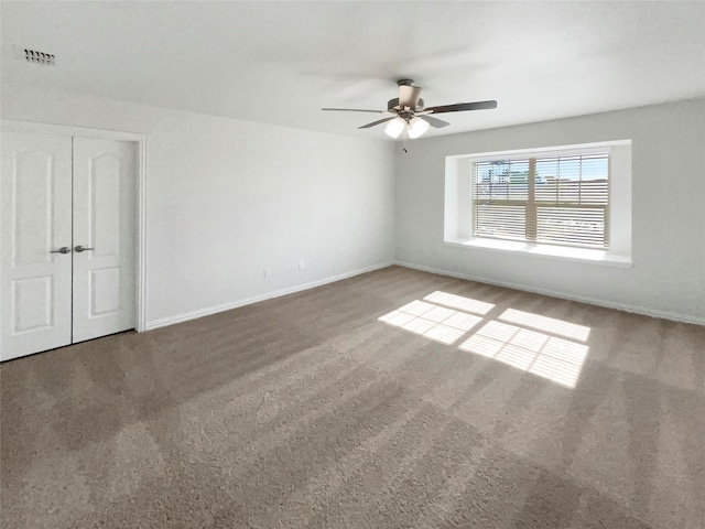 carpeted spare room featuring ceiling fan