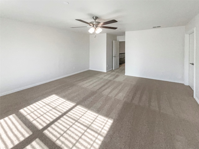 carpeted spare room featuring ceiling fan