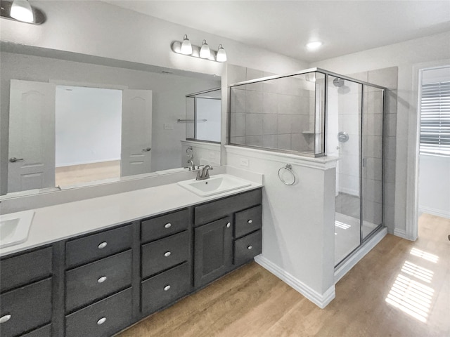 bathroom featuring vanity, an enclosed shower, and hardwood / wood-style flooring