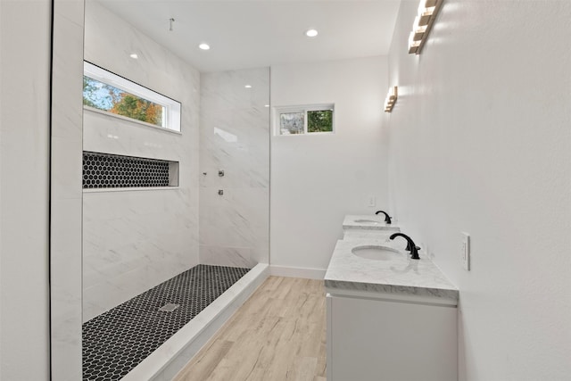 bathroom featuring tiled shower, a wealth of natural light, vanity, and hardwood / wood-style flooring