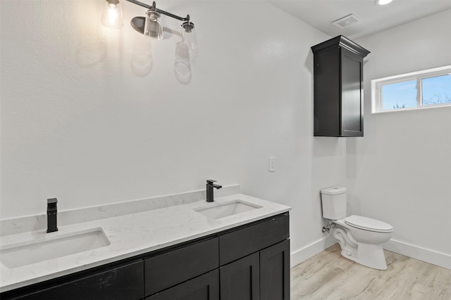 bathroom with vanity, toilet, and wood-type flooring