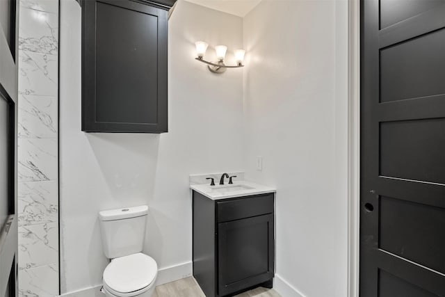 bathroom featuring wood-type flooring, vanity, and toilet