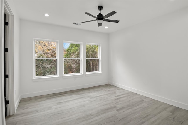 spare room featuring ceiling fan, a healthy amount of sunlight, and light wood-type flooring