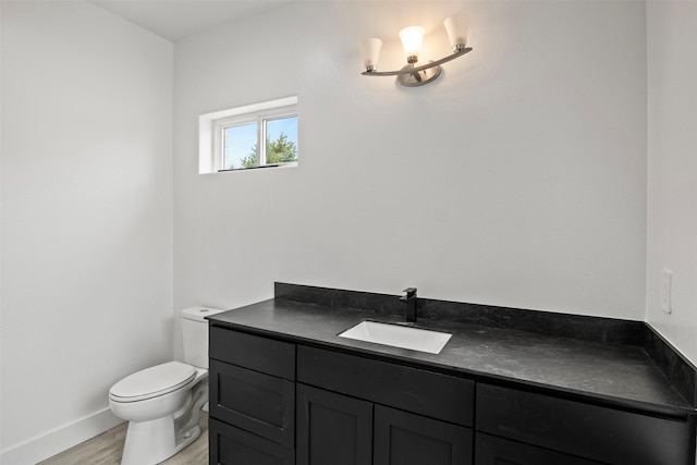 bathroom featuring vanity, wood-type flooring, and toilet