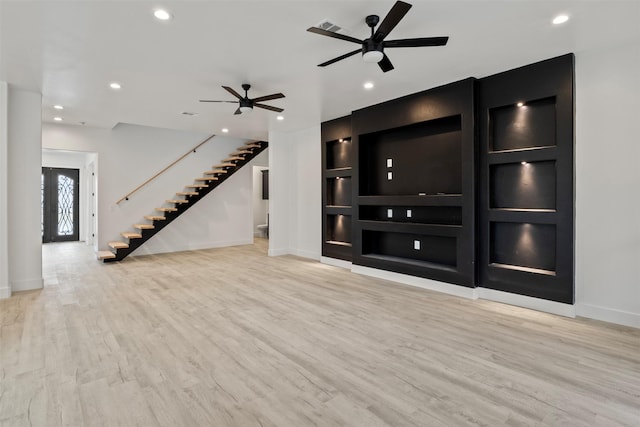 unfurnished living room featuring ceiling fan and light wood-type flooring