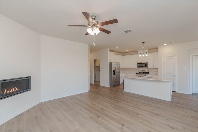 interior space featuring ceiling fan, light hardwood / wood-style floors, washer / dryer, and sink