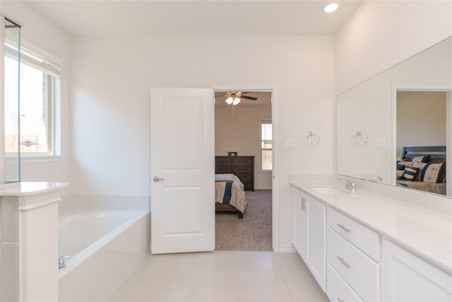 bathroom featuring tile patterned floors, a wealth of natural light, a washtub, and ceiling fan