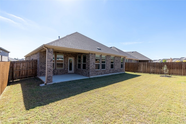 back of house with a lawn and a patio area