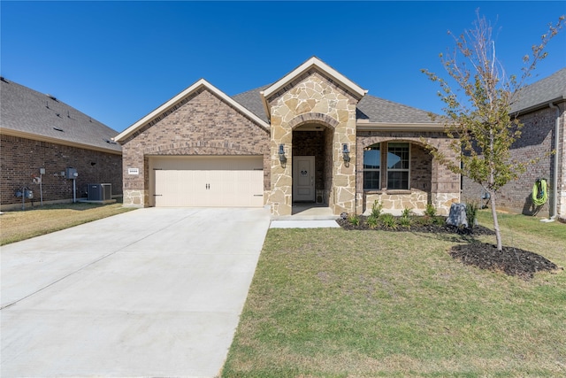 view of front of property with central AC, a front lawn, and a garage