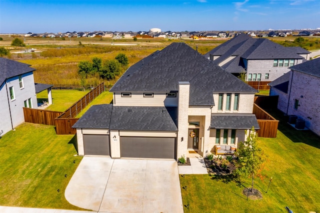 view of front of property featuring a front lawn, a garage, and a balcony