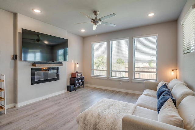 living room featuring light hardwood / wood-style flooring and ceiling fan