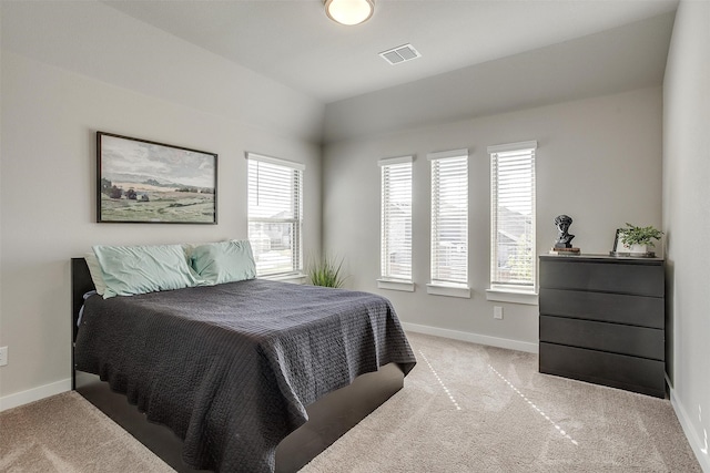 bedroom with multiple windows and light colored carpet