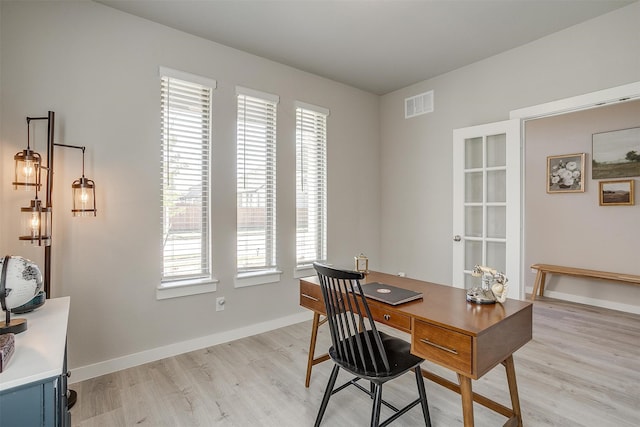 office space with light wood-type flooring and a healthy amount of sunlight