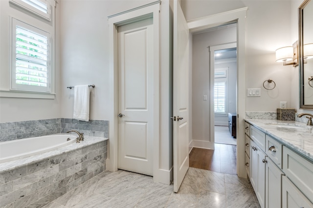 bathroom featuring vanity and tiled bath