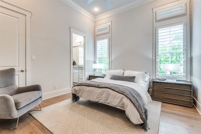 bedroom featuring connected bathroom, light hardwood / wood-style flooring, multiple windows, and ceiling fan