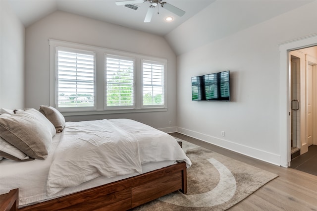 bedroom with dark hardwood / wood-style flooring, vaulted ceiling, and ceiling fan