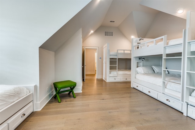 bedroom featuring lofted ceiling and light hardwood / wood-style flooring