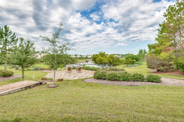 view of yard with a water view and a patio