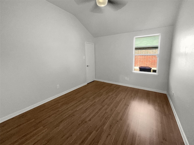 unfurnished room featuring ceiling fan, dark wood-style floors, baseboards, and lofted ceiling
