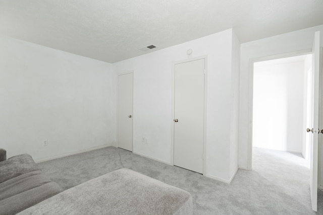 unfurnished bedroom featuring a closet and light carpet