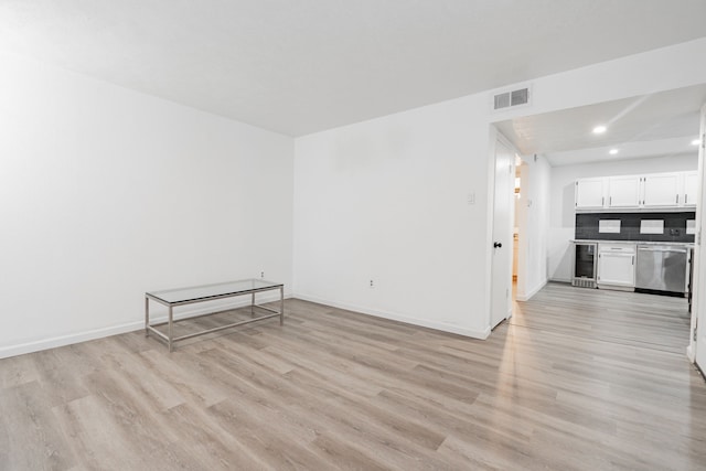 spare room with wine cooler and light hardwood / wood-style flooring